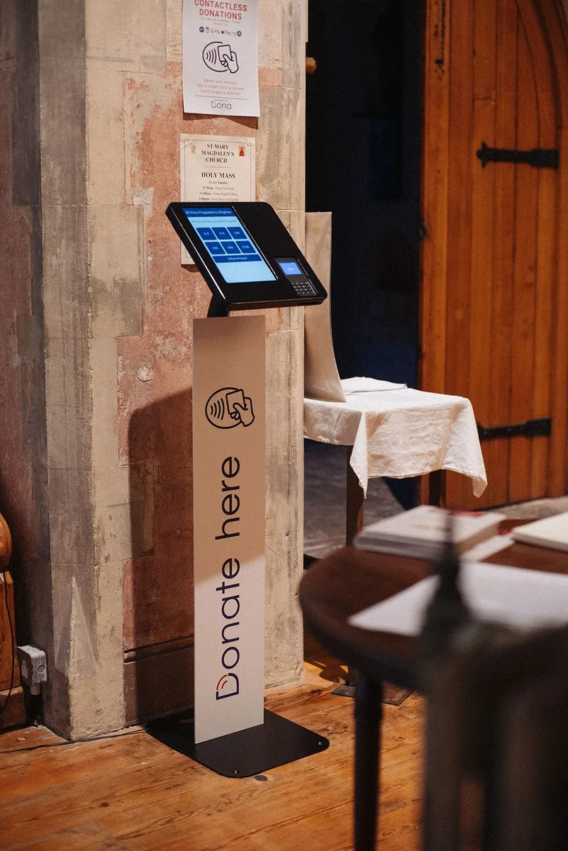 Donation stand 'Donate here' with contactless POS in a church